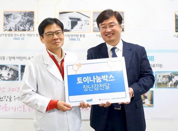 김기호(오른쪽) CJ헬스케어 상무는 김재복 서울시어린이병원장에 ‘토이나눔박스'를 전달하고 있다. [사진=CJ헬스케어]